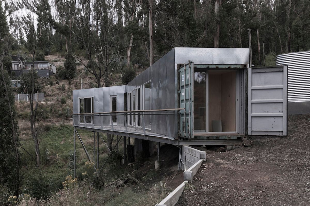 Shipping Container House Floats Among the Trees with Ocean Views