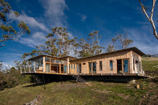Bruny Shore House is made from timber and hangs over a slope towards the ocean at Bull Bay in Tasmania