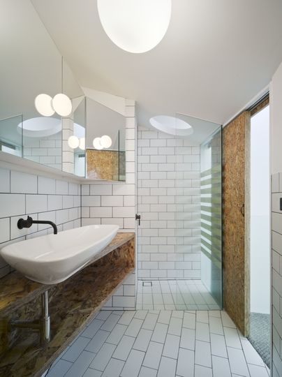 Bathroom in white and oriented strand board feels light and airy at the Cubby House project