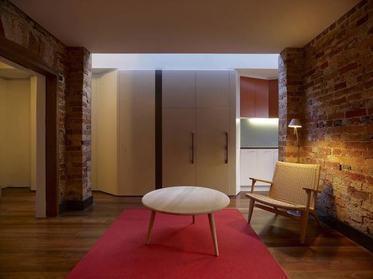 Fitzroy Terrace in Sydney's lounge area feels warm with reds and the original brickwork and details