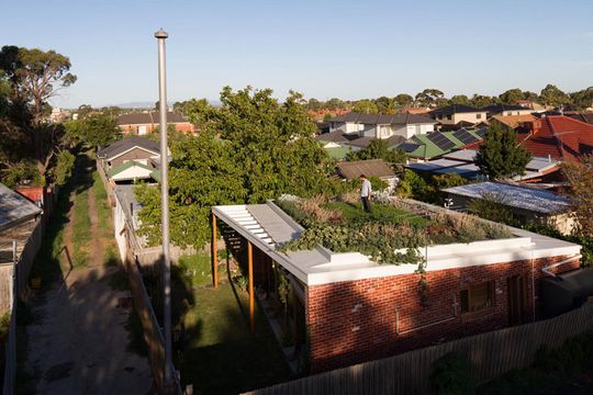 Emilio from Nest Architects waters his Florence Street House green roof in suburban Melbourne