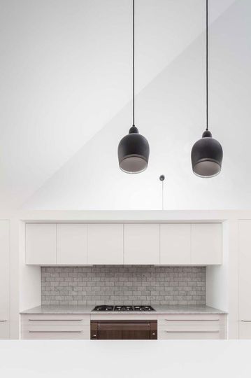 House Chapple's white kitchen has a textured dove gray tile splash back to inject texture and variety