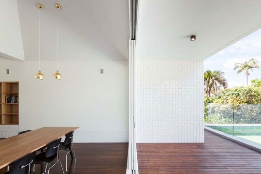 A seamless transition from the dining area to the deck area is created by using matching materials inside and out and a huge sliding glass door