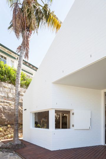 Outside House Chapple's painted white brick matches the original, while also creating a sense of retro glamor