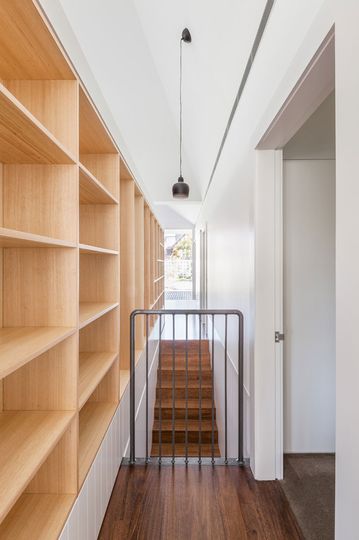 Timber shelving and minimalist details keep the interior of House Chapple minimal and light