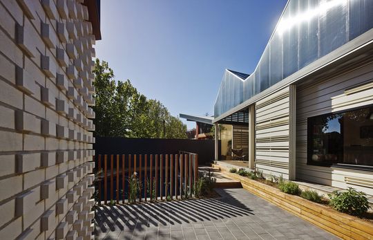 The polycarbonate facade shimmers during the day adding to other rich textural materials like the textured brick facade