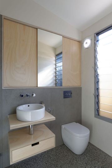 Islington House bathroom uses fiber cement sheet, plywood and an exposed aggregate concrete floor