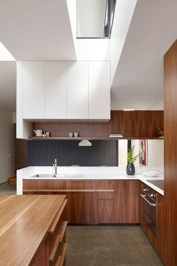 North Fitzroy House kitchen uses timber veneer and a textured white panel it's richly textured
