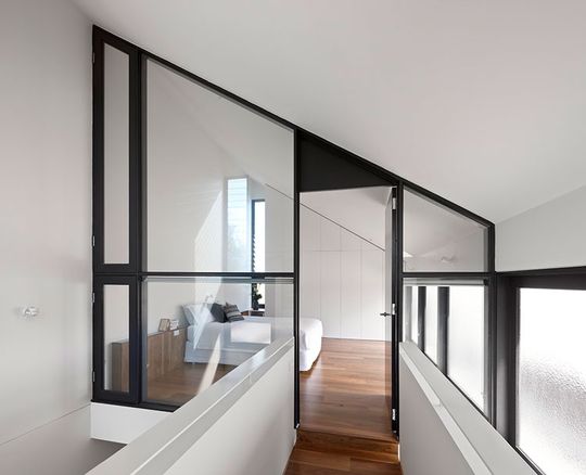 The bedroom is surrounded by glass, giving it acoustic privacy, but making it feel more like a mezzanine loft at North Fitzroy House