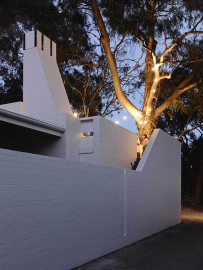 Lights in the eucalyptus tree light up the upstairs terrace in Park Lane House