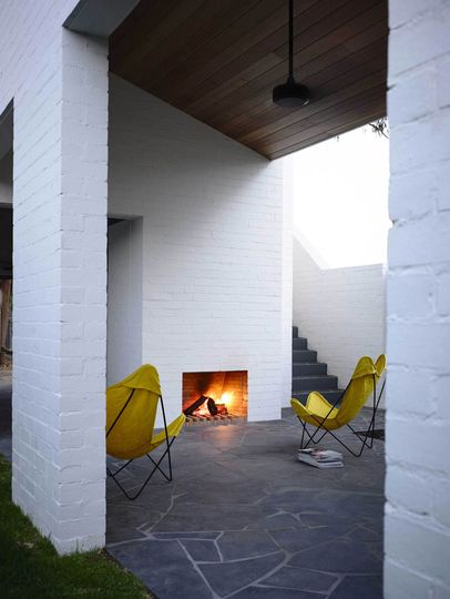 A covered external courtyard is warmed by a fireplace