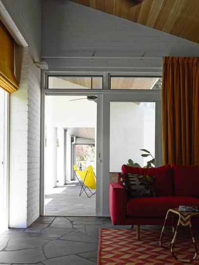 Connection between the indoors and outdoors thanks to a sliding glass door and the continuation of the floor surface