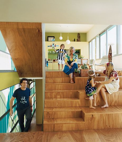 Michel Bellemo, Cat Macleod and their family sit on their amphitheater style stairs in their home Polygreen