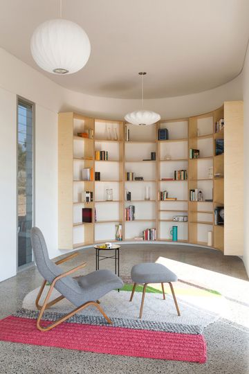 In the curved wall of the Southern Highlands House a custom plywood bookshelf fits perfectly