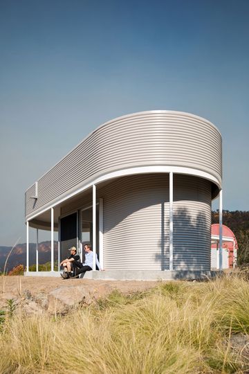 Two men sit on the verandah of the Southern Highlands House enjoying the stunning view
